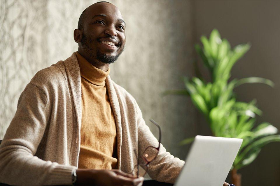 MBA student smiling while reviewing coursework on a laptop.